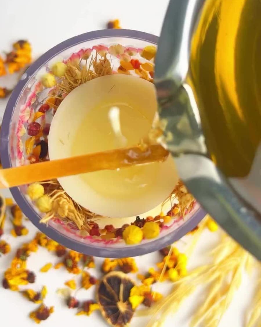 Olesia hand pouring botanical candles in the Candera studio