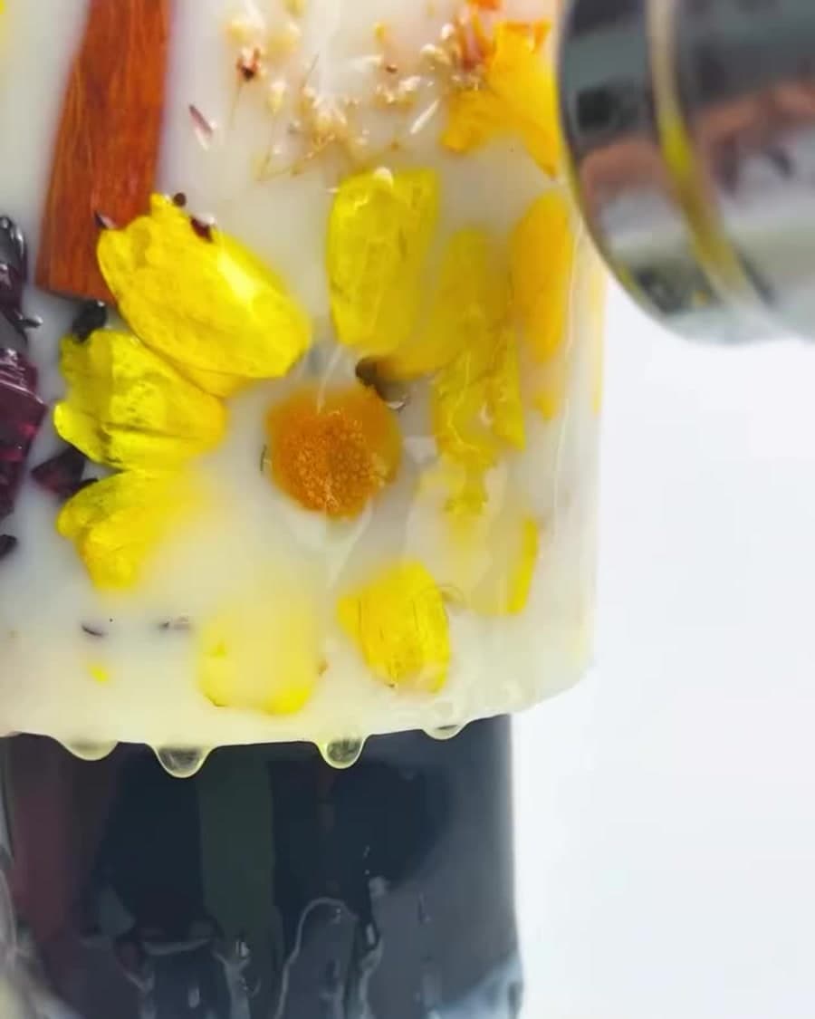 Botanicals pressed into a Candera candle, poured by hand